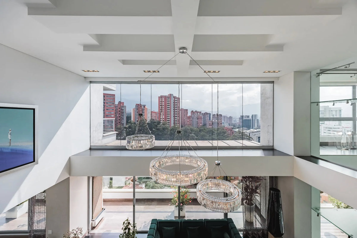 Moderna sala con ventanales de piso a techo y salida directa a una terraza con vista 360°, en apartamento de lujo en El Poblado Medellín.