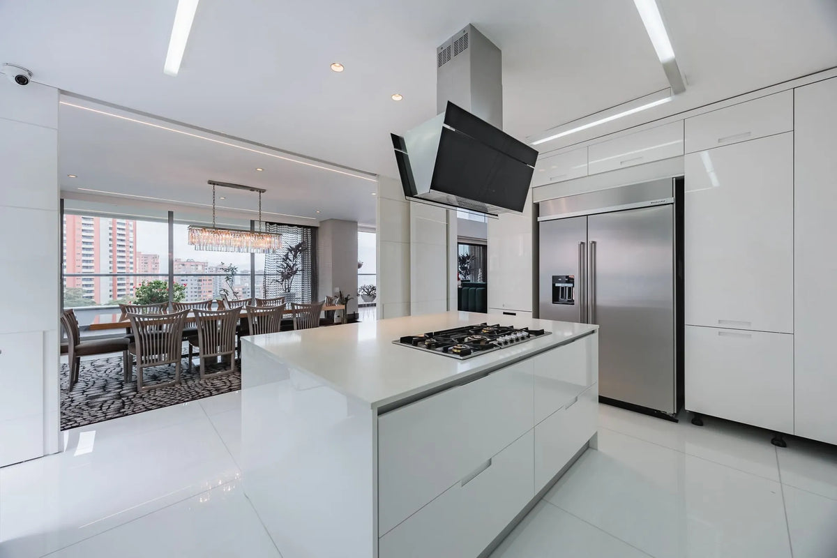 Espaciosa cocina abierta con acabados de lujo y acceso a la terraza con BBQ y zona social, en apartamento en venta en El Tesoro Medellín.