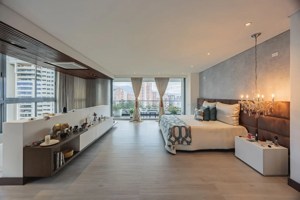Dormitorio principal con acceso a balcón privado y vista al sur de Medellín, dentro de un apartamento de 5 habitaciones en El Poblado.