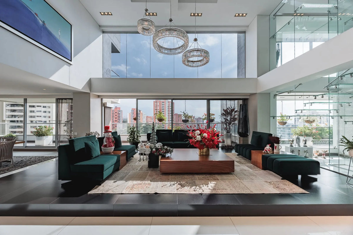 Moderna sala con ventanales de piso a techo y salida directa a una terraza con vista 360°, en apartamento de lujo en El Poblado Medellín