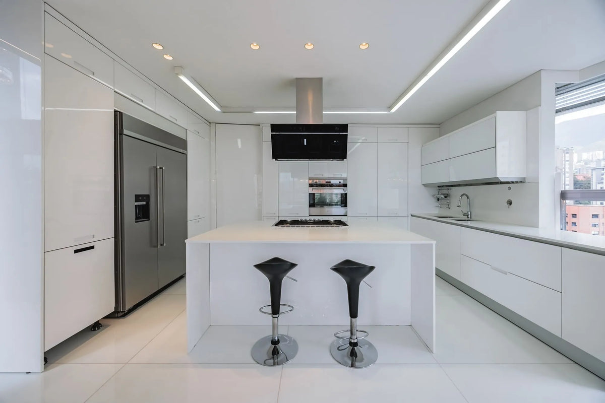 Espaciosa cocina abierta con acabados de lujo y acceso a la terraza con BBQ y zona social, en apartamento en venta en El Tesoro Medellín.