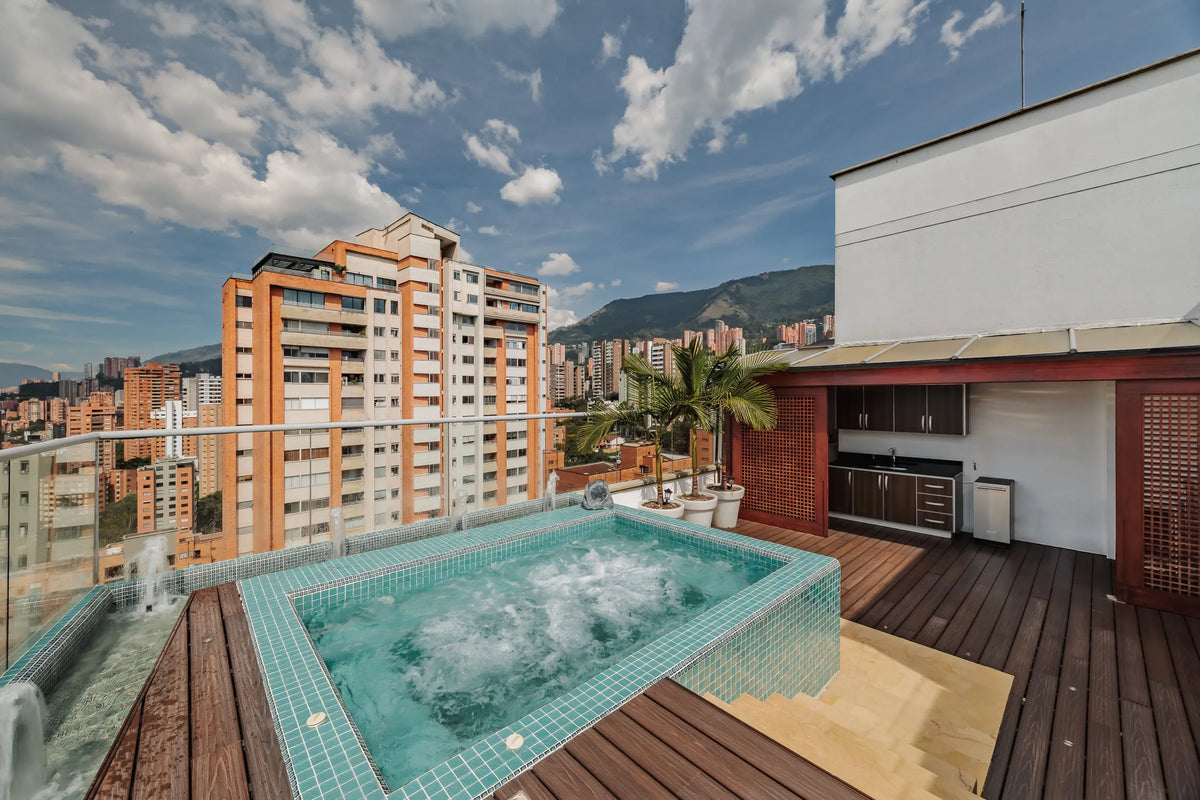 Jacuzzi privado al aire libre en amplia terraza con zona BBQ, parte del penthouse en venta en Milla de Oro, sector exclusivo de Medellín