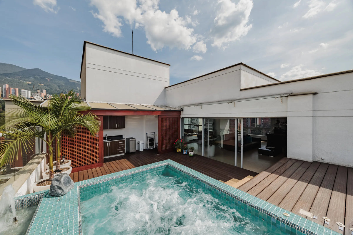 Jacuzzi privado al aire libre en amplia terraza con zona BBQ, parte del penthouse en venta en Milla de Oro, sector exclusivo de Medellín.