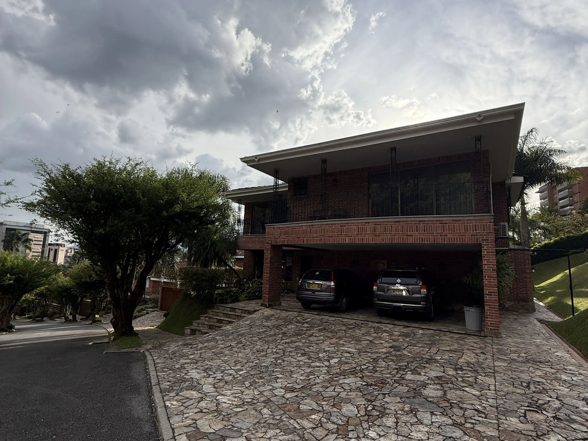 Fachada de casa en El Poblado con amplio lote y jardines.