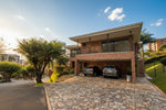 Fachada de casa en El Poblado con amplio lote y jardines.