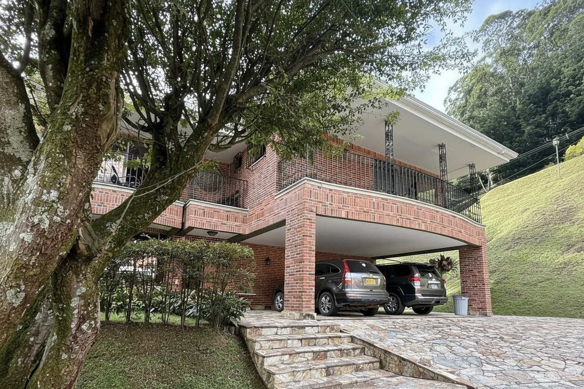 Fachada de casa en El Poblado con amplio lote y jardines.