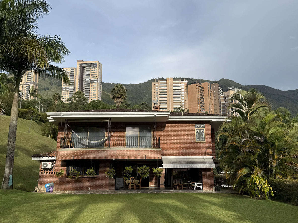 Fachada de casa en El Poblado con amplio lote y jardines.