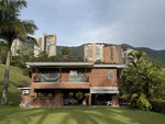 Fachada de casa en El Poblado con amplio lote y jardines.