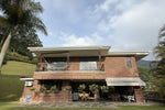 Fachada de casa en El Poblado con amplio lote y jardines.