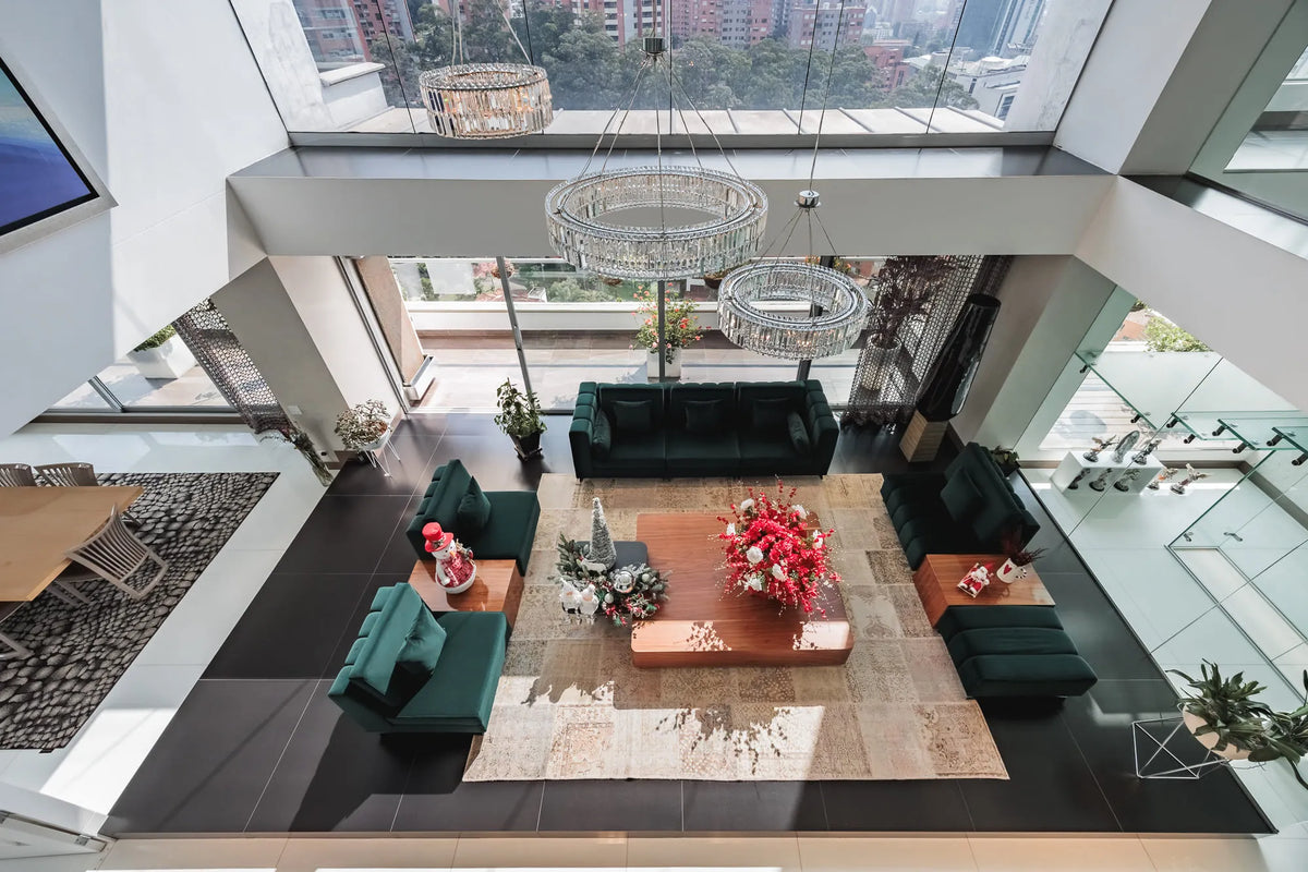 Moderna sala con ventanales de piso a techo y salida directa a una terraza con vista 360°, en apartamento de lujo en El Poblado Medellín.