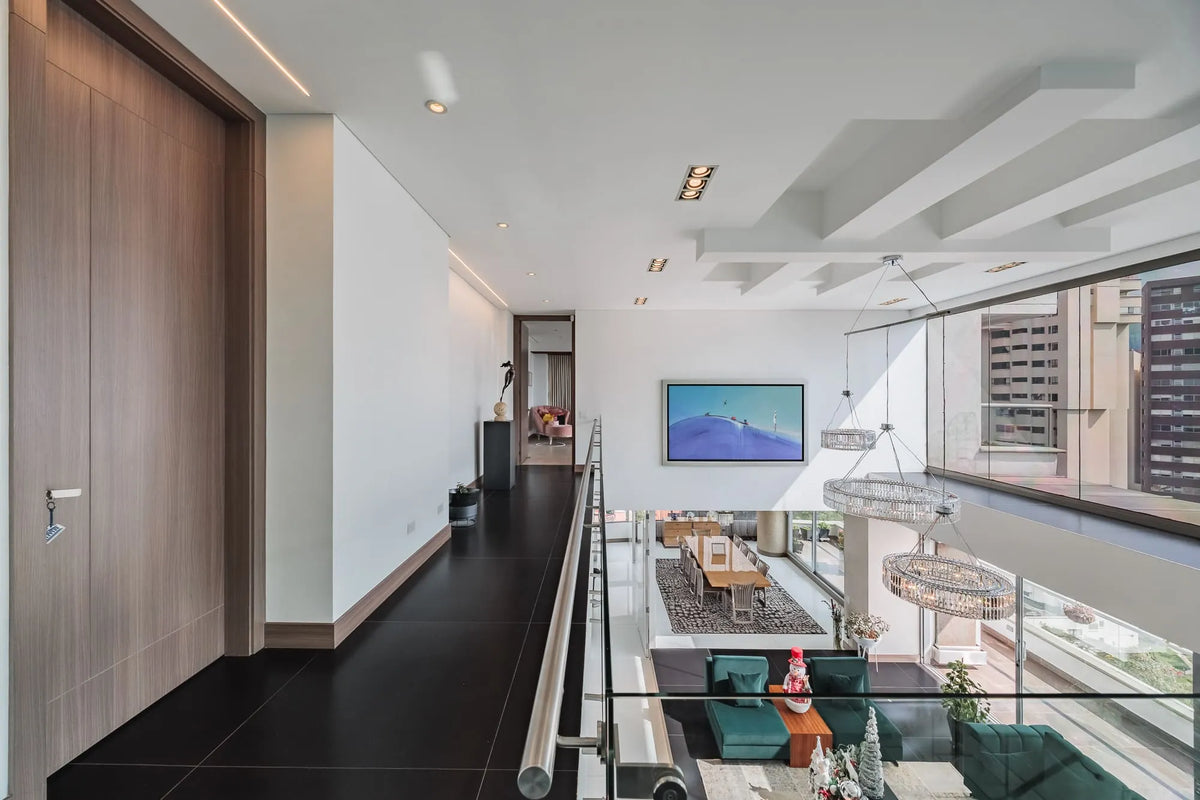 Moderna sala con ventanales de piso a techo y salida directa a una terraza con vista 360°, en apartamento de lujo en El Poblado Medellín.