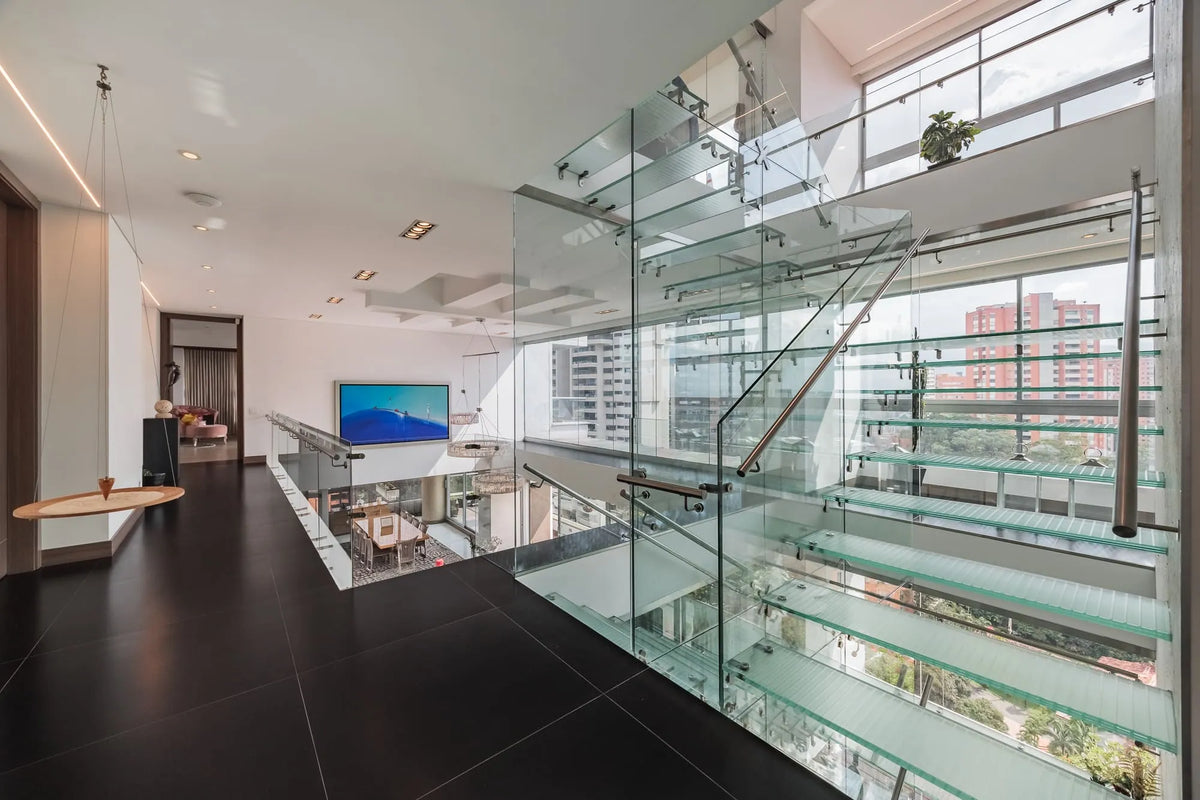 Moderna sala con ventanales de piso a techo y salida directa a una terraza con vista 360°, en apartamento de lujo en El Poblado Medellín.