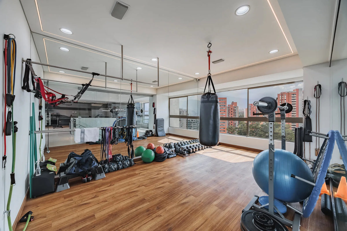 Gimnasio privado totalmente equipado en apartamento de lujo en El Poblado, con acceso directo a la terraza panorámica.
